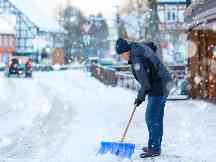 Gothaer Haus- und Grundbesitzerhaftpflicht: Ein Hausbesitzer räumt vor seinem Haus den Schnee weg.
