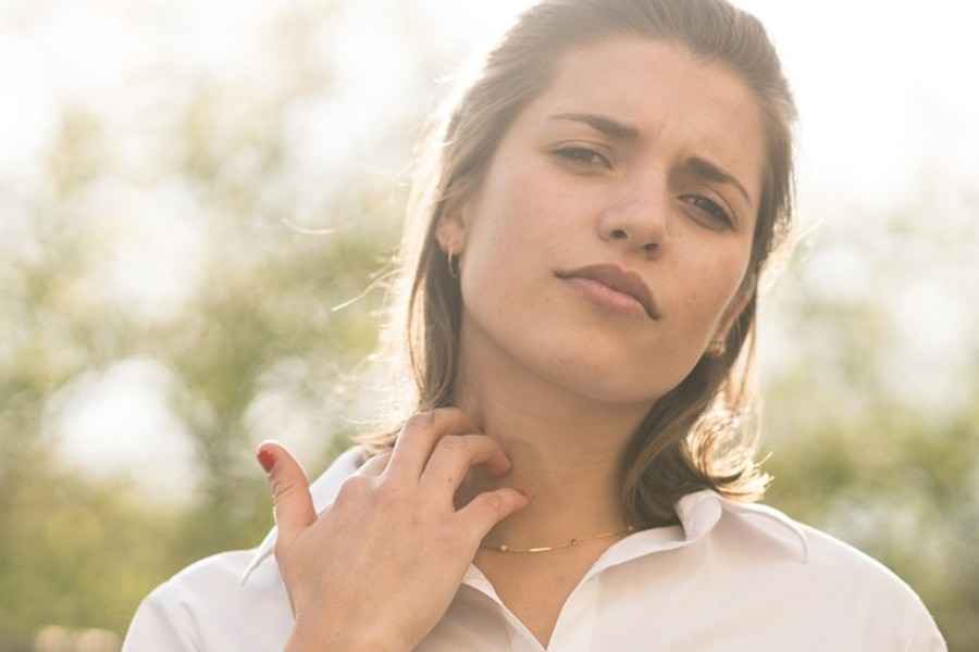 Frau mit Stich am Hals: Wie können Sie Mückenstiche vermeiden?