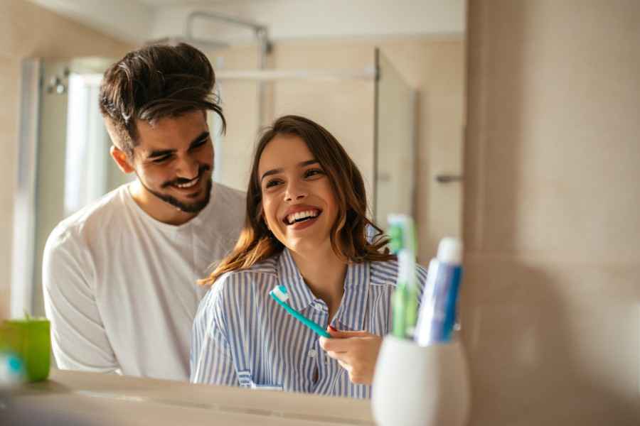 Gothaer Ratgeber Zahnfleischentzündung: Eine junge Frau und ein junger Mann putzen sich die Zähne.
