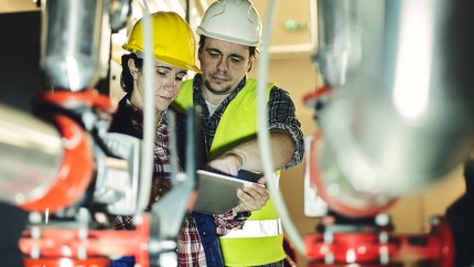 Umweltschadenversicherung: Leitende Angestellte in Warnweste und mit Helm im Werk Umweltschadenversicherung: Leitende Angestellte in Warnweste und mit Helm im Werk