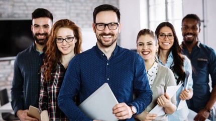 Gothaer Gruppenunfallversicherung: Junge Unternehmensmitarbeiter lachen in die Kamera. Gothaer Gruppenunfallversicherung: Junge Unternehmensmitarbeiter lachen in die Kamera.