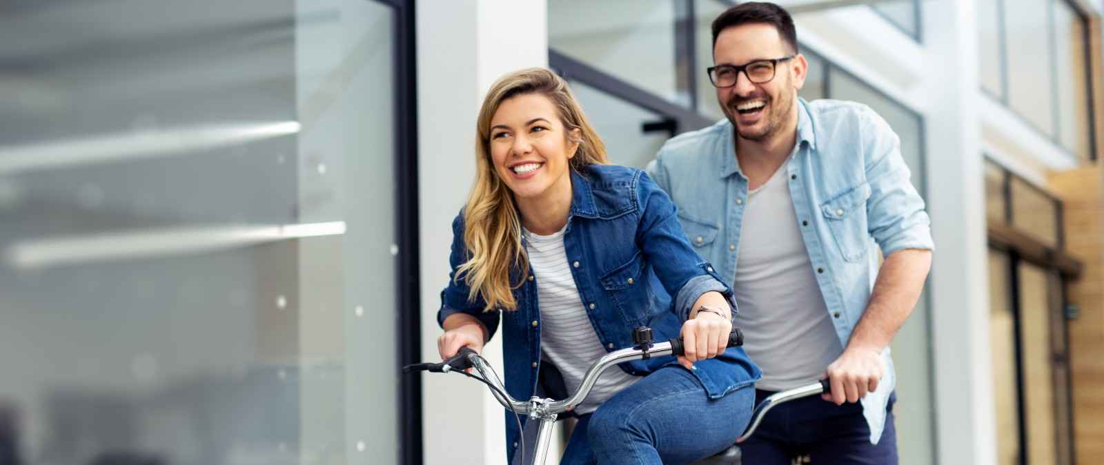 Junges Paar mit Fahrrad freut sich über die Gothaer Direktversicherung.