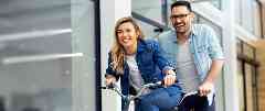 Junges Paar mit Fahrrad freut sich über die Gothaer Direktversicherung.