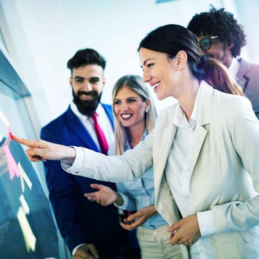 Bei der Arbeitgeberfinanzierung profitieren Sie als Mitarbeiter von der betrieblichen Krankenversicherung: Büroangestellte arbeiten an einem Board.