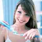 Junge Frau, die sich die Zähne putzt.