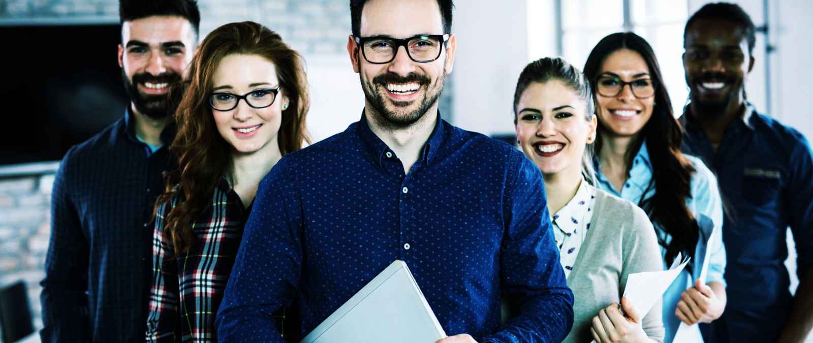 Gothaer Gruppenunfallversicherung: Junge Unternehmensmitarbeiter lachen in die Kamera.