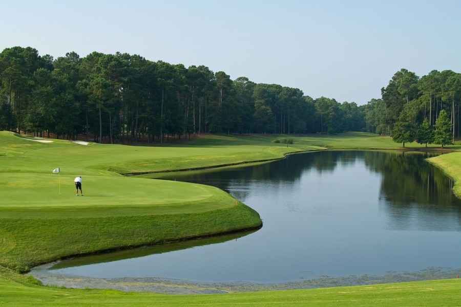 Golfplatz mit einem Golfspieler in Fernaufnahme