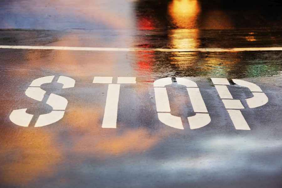 Strassenmarkierung "Stop" im Licht einer Autolampe