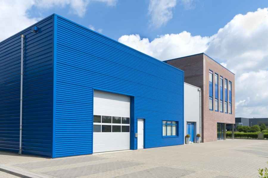 Ein Firmengebäude mit angeschlossener Produktionshalle im Vordergrund