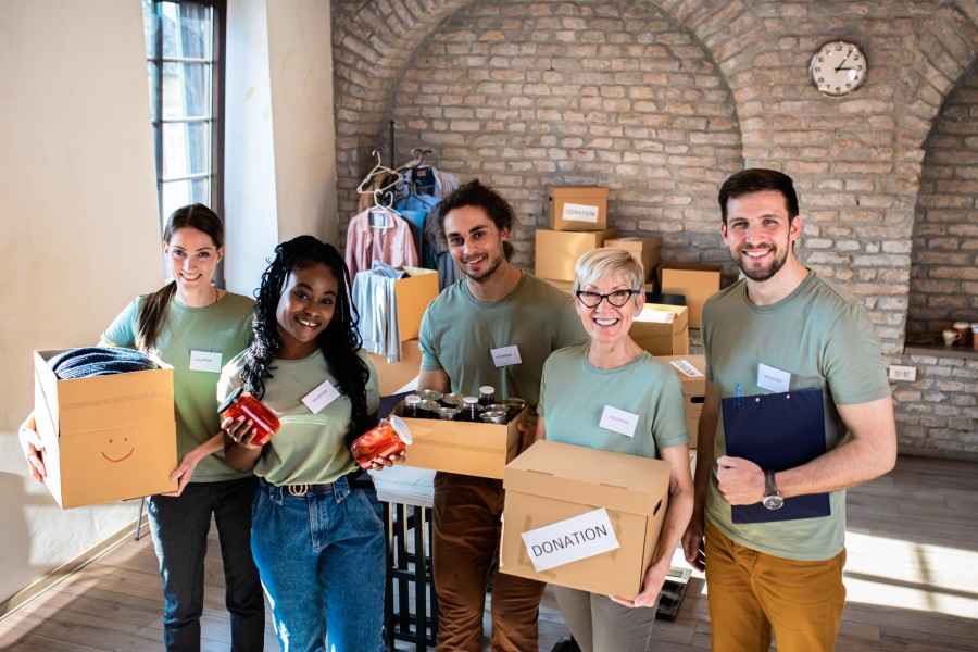 Eine Gruppe junger Menschen packen ehrenamtlich Sachen zum Spenden zusammen. 