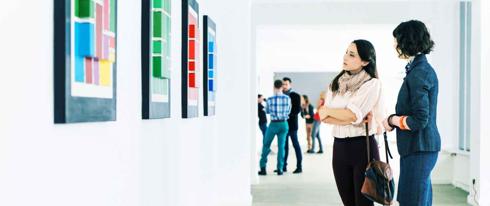 Gothaer Kunstausstellungsversicherung: Besucher*innen bewundern moderne Kunst auf einer Kunstausstellung.