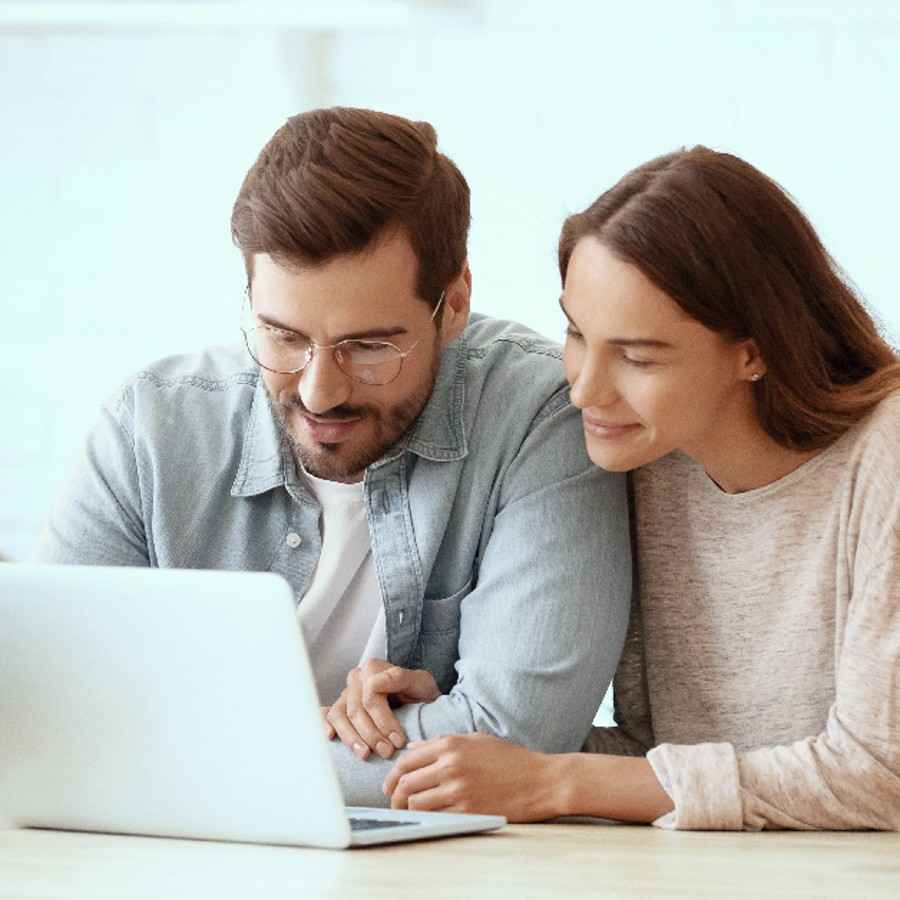 Kapitalanlagen: Paar im Wohnzimmer vor Laptop