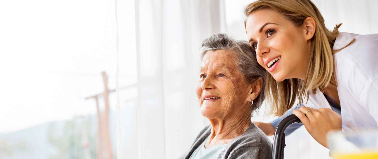 Pflegerin mit Patientin im Rollstuhl