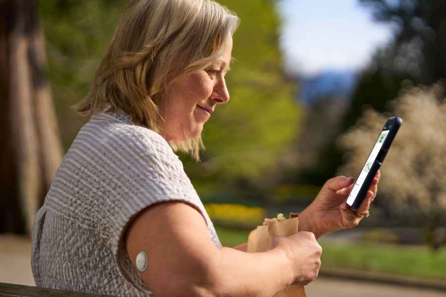 Eine Frau nutzt FreeStyle Libre auf ihrem Smartphone