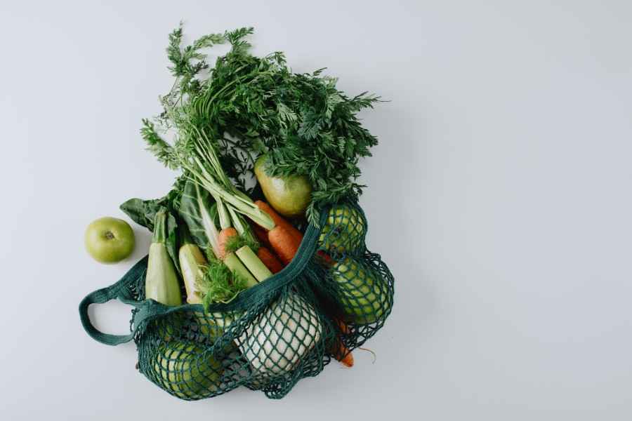 Einkaufsnetz gefüllt mit frischem Gemüse und Obst / Shopping net filled with fresh vegetables and fruits 