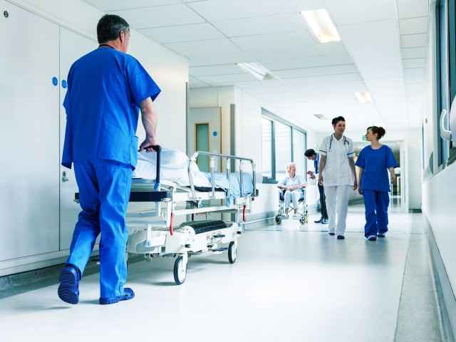 Pfleger im Krankenhaus schiebt Bett