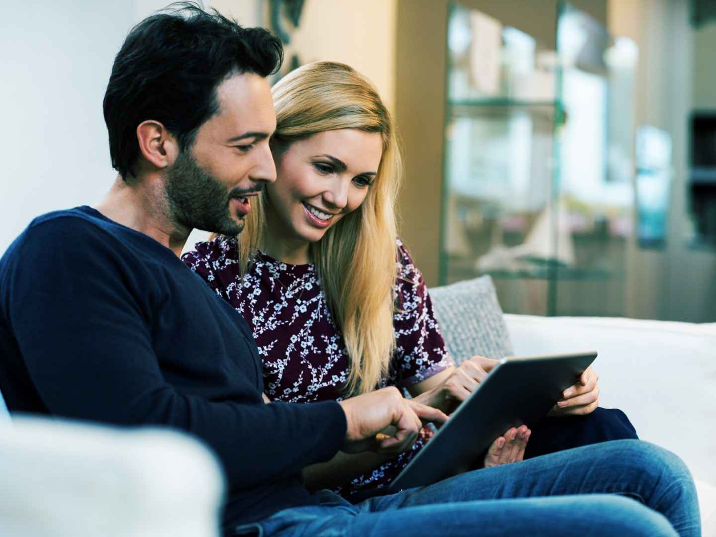 Treffen Sie die richtige Wahl bei der Krankenhaussuche: Paar auf der Couch schaut in den Laptop.