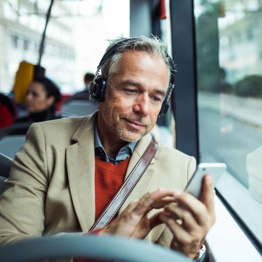 Ein Mann im Bus benutzt die Tinnitus-App.