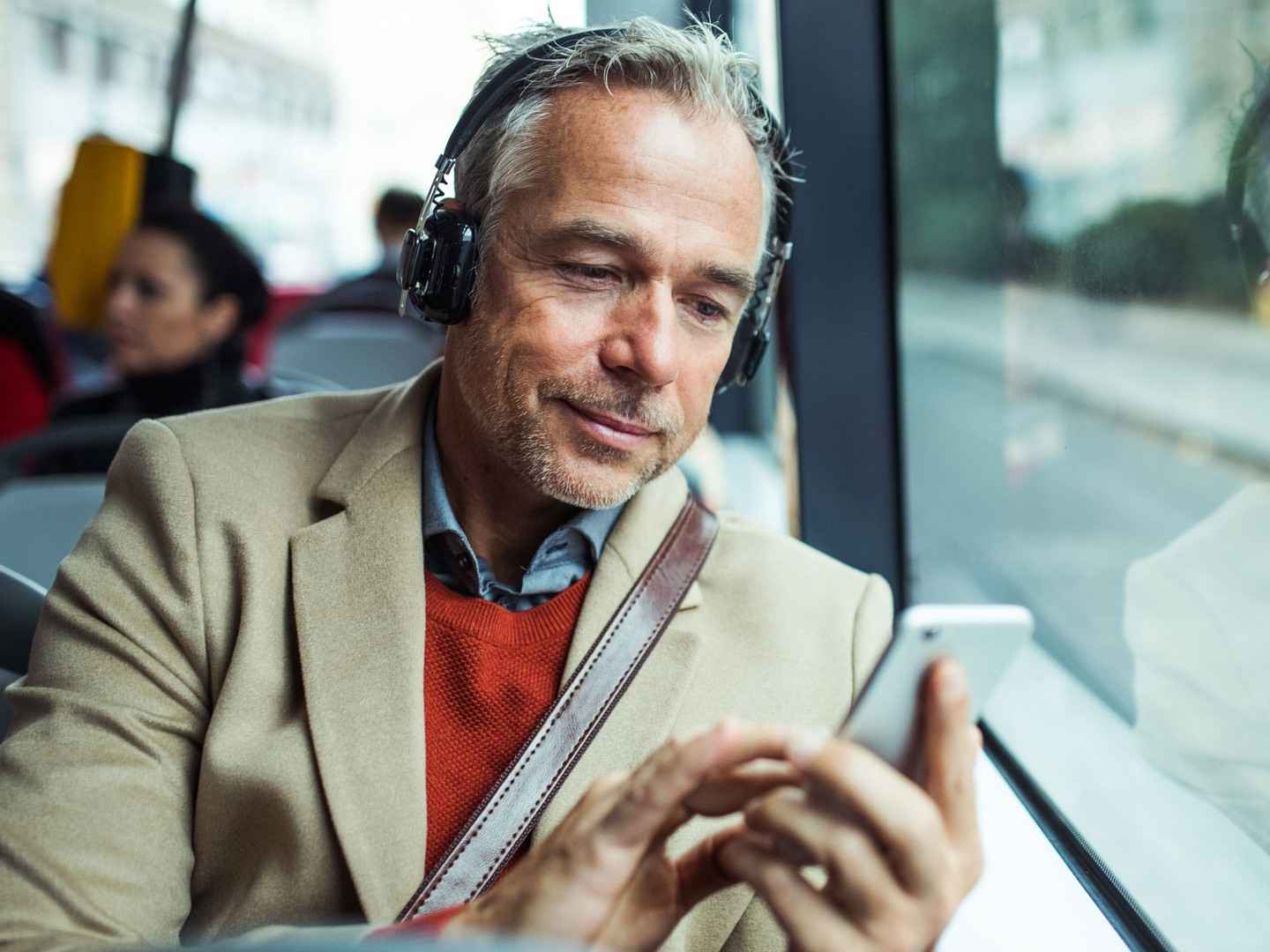 Ein Mann im Bus benutzt die Tinnitus-App.