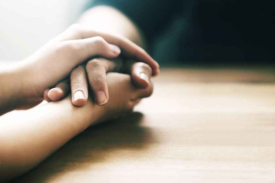 Zwei Hände ergreifen Hand einer Person