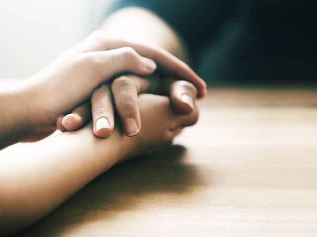 Zwei Hände ergreifen Hand einer Person