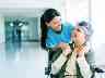 Pflegetagegeldversicherung: Ältere Frau im Rollstuhl mit Pflegerin