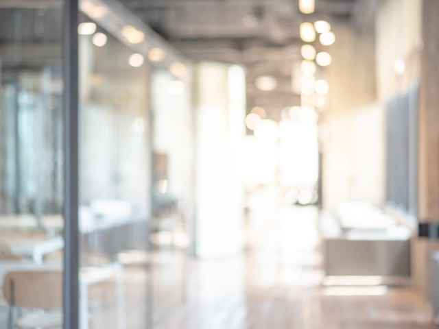 Bürogang mit Glasbüros auf der linken Seite