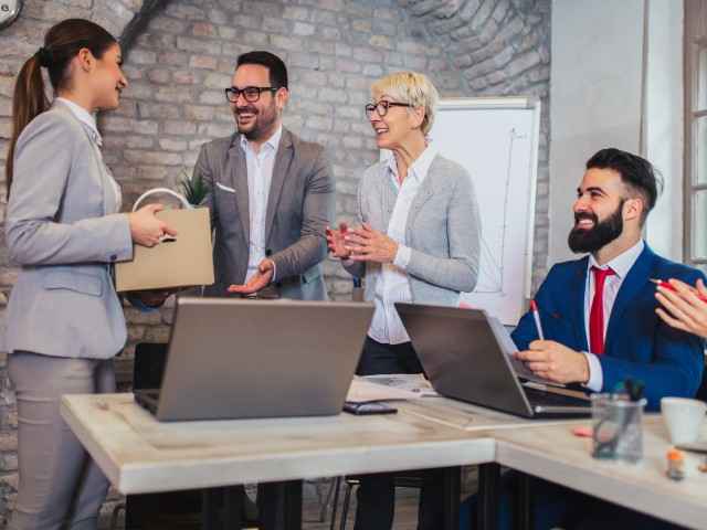 Mehrere Mitarbeiter*innen begrüßen ein neu hinzugekommenes Teammitglied