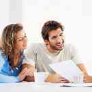 Wohnbaufinanzierung: Ehepaar lässt sich beraten und verschafft sich einen Überblick über Darlehen und Zinsen.