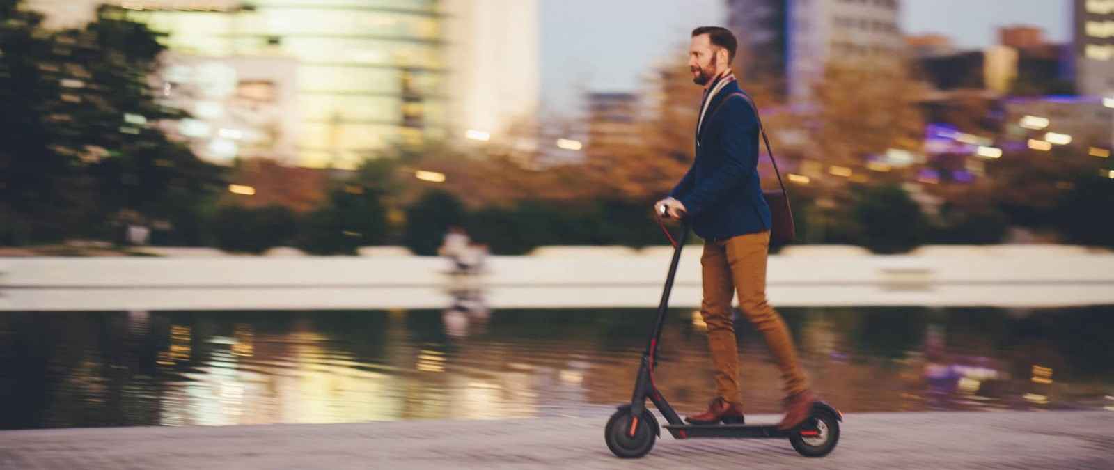 Gothaer E-Scooter-Versicherung: Mann fährt auf einem E-Scooter.