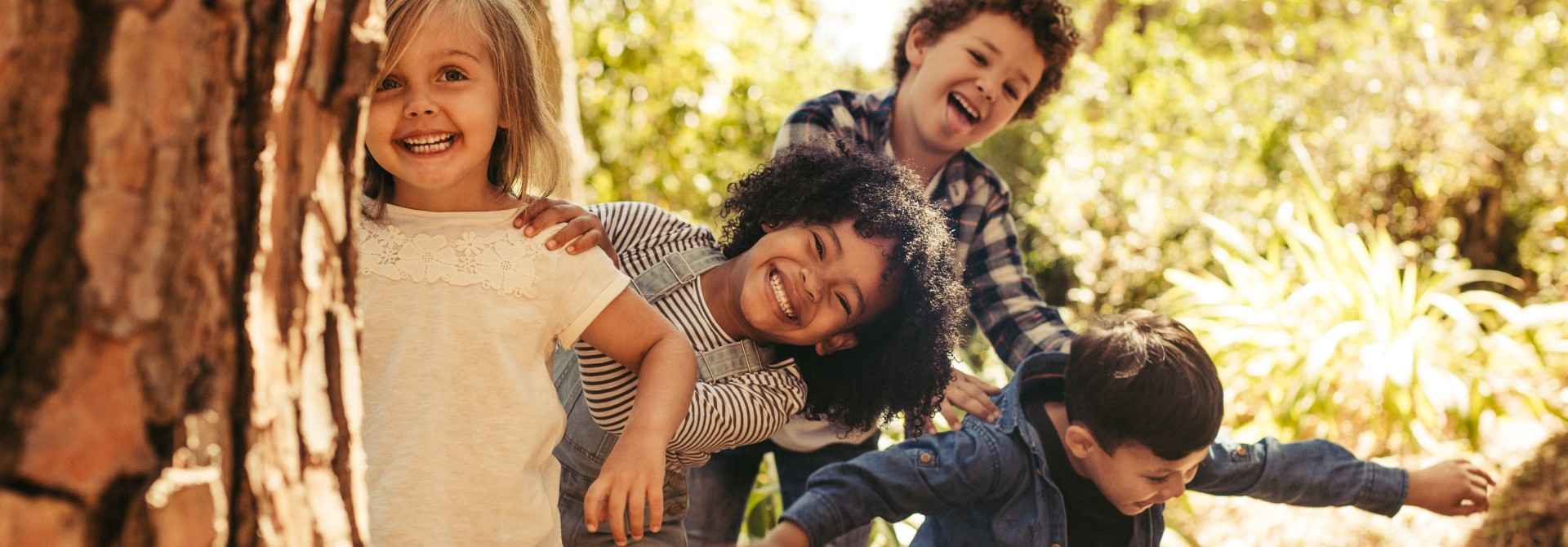 Kinderversicherungen Gothaer Kids: 4 Kinder spielen voller Freude im Wald