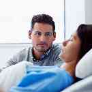 Gothaer Krankentagegeld: Mann ist froh über die guten Leistungen seiner Zusatzversicherung, während er am Krankenbett seiner Frau wacht.