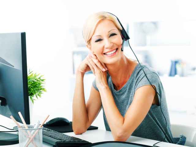 Telefonische Rechtsberatung JurLine: Frau vor Computer mit Headset