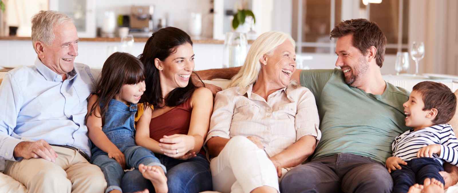 Gothaer Parkkonto: Eine glückliche Familie sitzt auf dem Sofa.