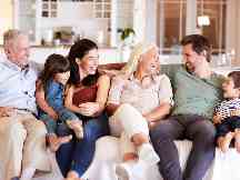 Gothaer Parkkonto: Eine glückliche Familie sitzt auf dem Sofa.