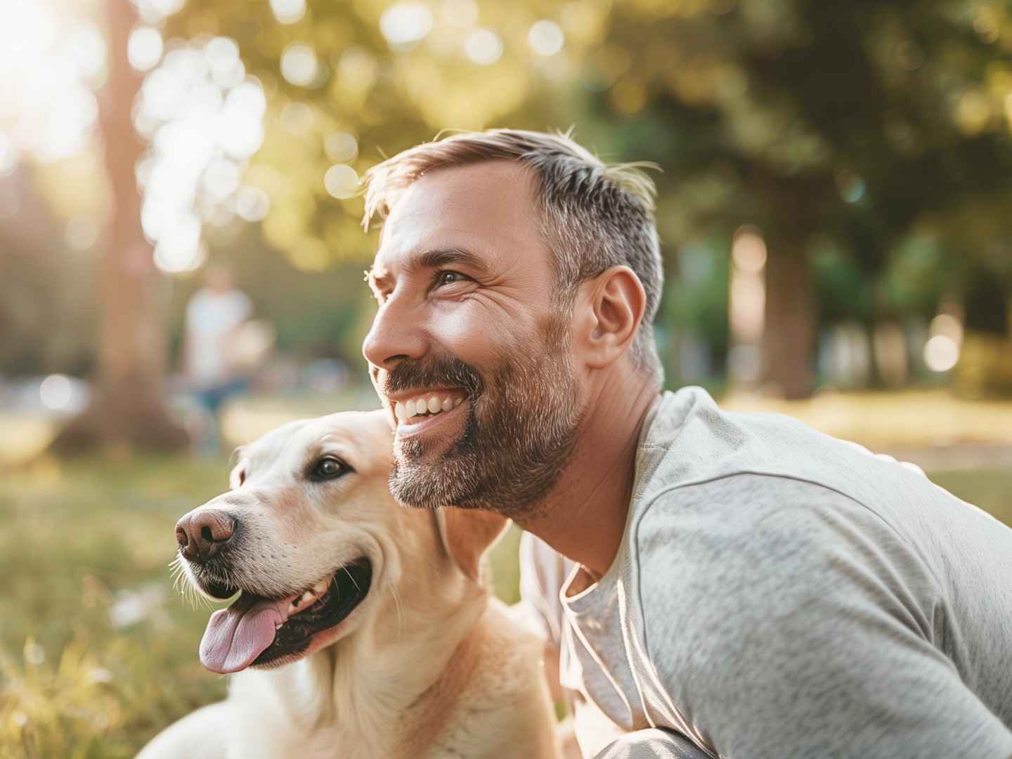 Tierhalterhaftpflicht: Ein junger Mann lacht, weil sein Hund ihm das Gesicht ableckt.