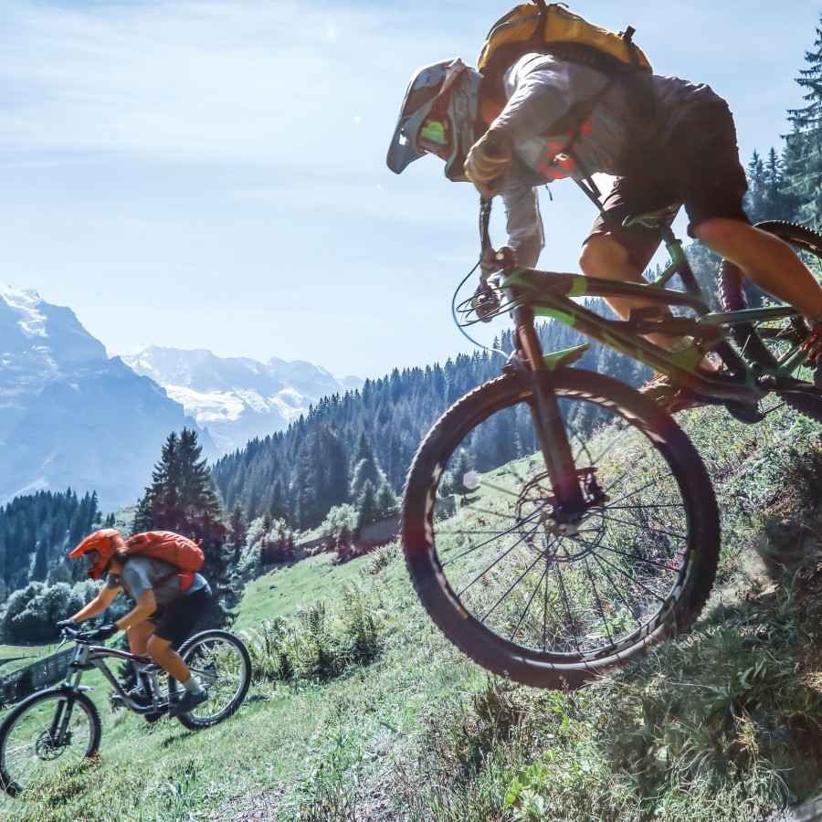 Gothaer Unfallversicherung: Mountainbiker fahren einen steilen Hang hinunter