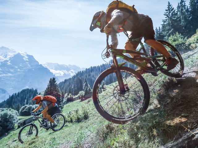 Gothaer Unfallversicherung: Mountainbiker fahren einen steilen Hang hinunter