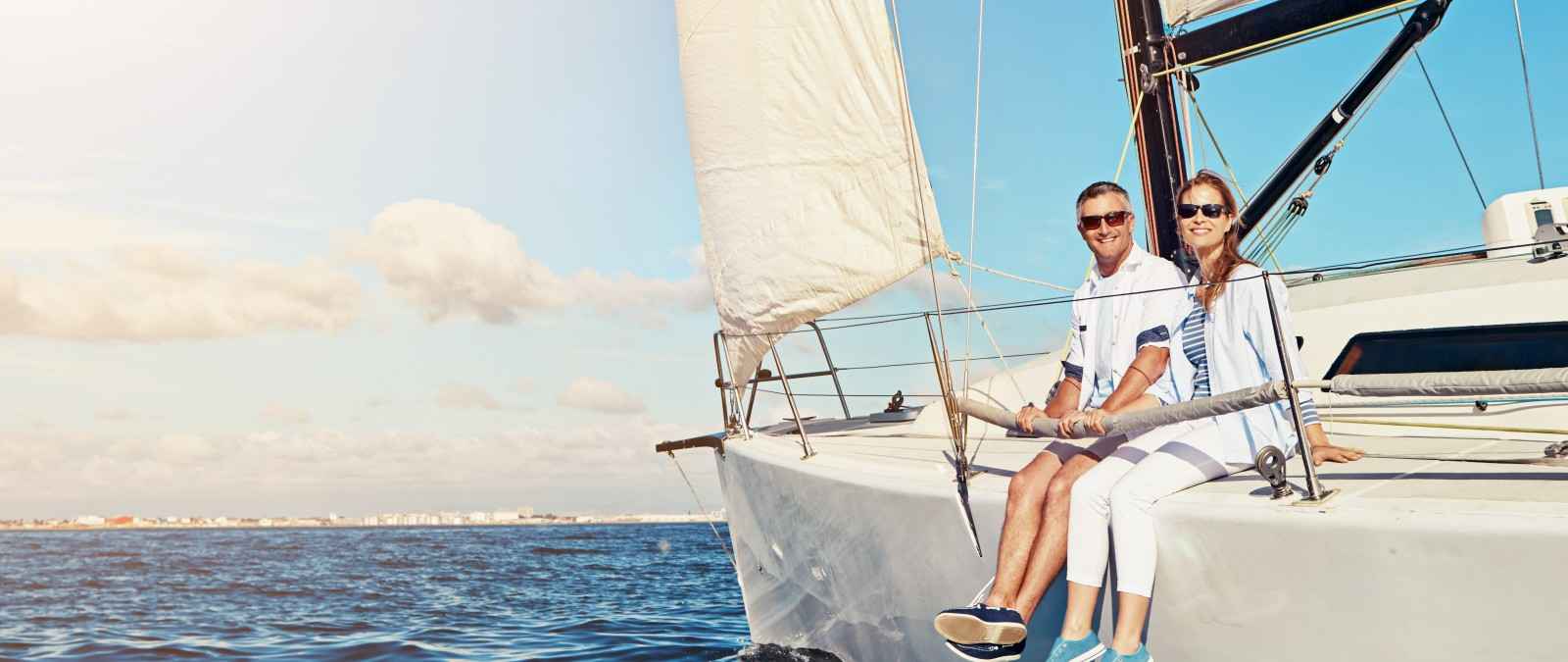Gothaer Wassersportversicherung: Paar auf seiner Yacht liebt den Wassersport.