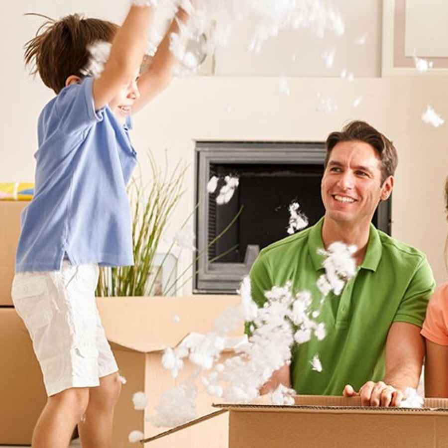 Eltern freuen sich mit ihren Kindern über den Einzug in ihr eigenes Haus.
