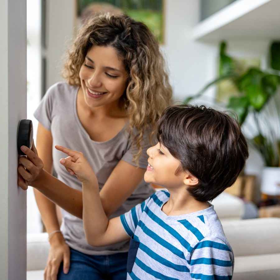 Mutter und Sohn machen sich mit dem Thermostat für die neue Wärmepumpe vertraut