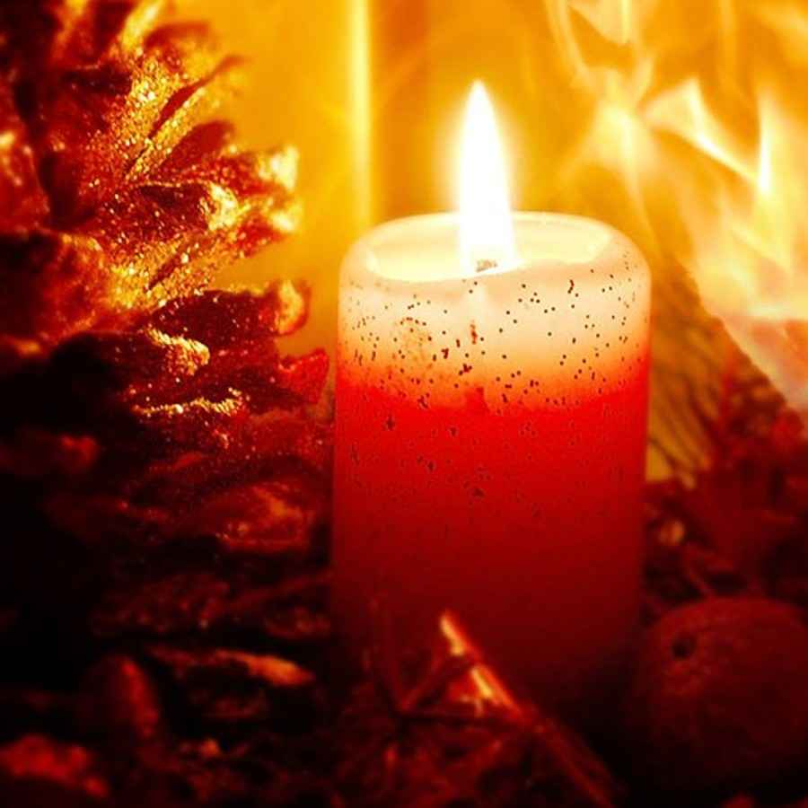Brennende Kerze mit Feuer im Hintergrund