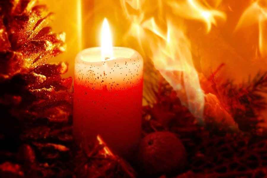 Brennende Kerze mit Feuer im Hintergrund