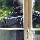 Einbrecher mit ein einer Knippstange vor einem Fenster