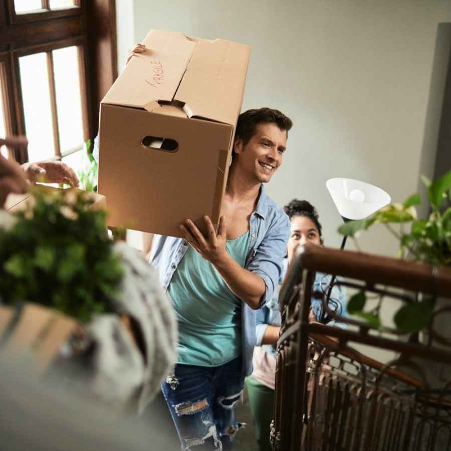 Private Haftplfichtversicherung schützt: Freunde helfen beim Umzug und tragen Kartons. 