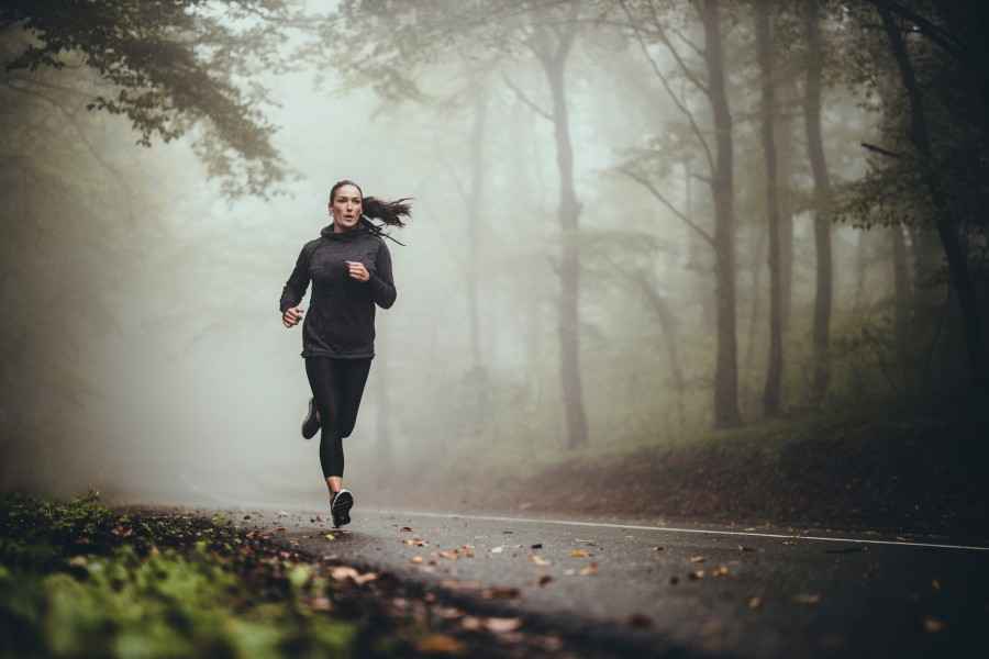 Frau joggt im Herbst