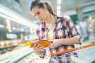 Ernährung: Frau kauft im Supermarkt ein und achtet auf gesunde Produkte.