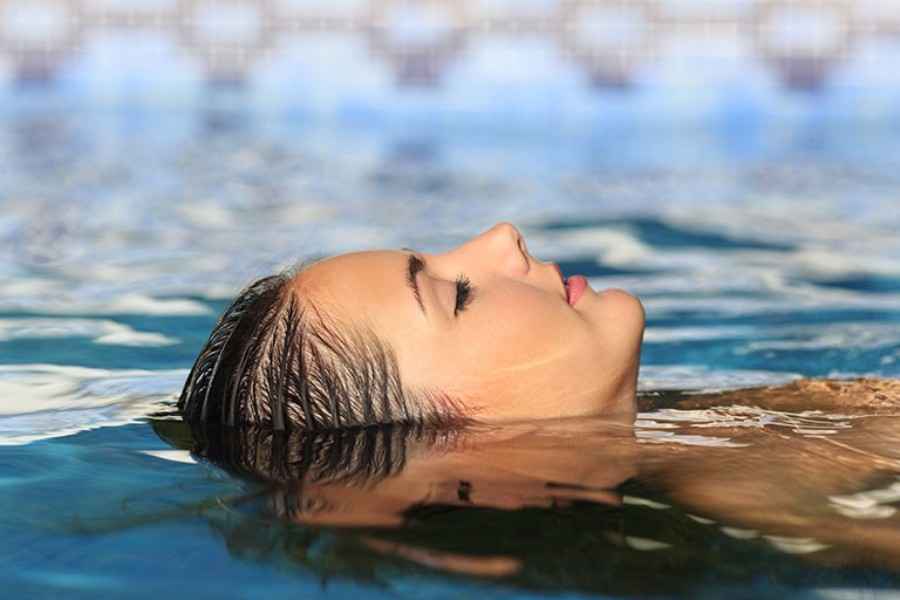 Gesundheit: Frau liegt auf dem Rücken im Wasser
