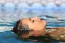 Gesundheit: Frau liegt auf dem Rücken im Wasser