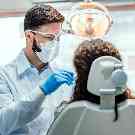 Ein Zahnarzt untersucht eine Frau auf Parodontitis.